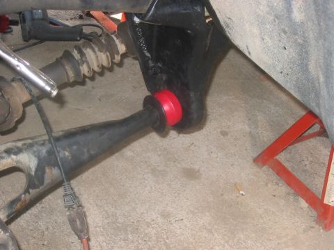 1988 Ford Bronco - Close-up of a suspension component with a red bushing, likely part of a lift installation.