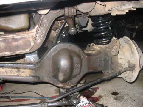 1988 Ford Bronco - Close-up view of the rear axle and suspension system, highlighting a newly installed black coil spring.