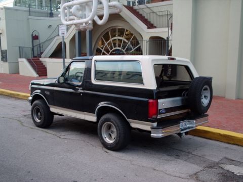 1993 Ford Bronco - This Ford Bronco is parked on a street with a building in the background.