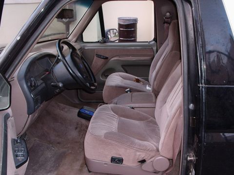 1993 Ford Bronco - The interior of a 1992 Ford Bronco, tan cloth seats and a dark dashboard.