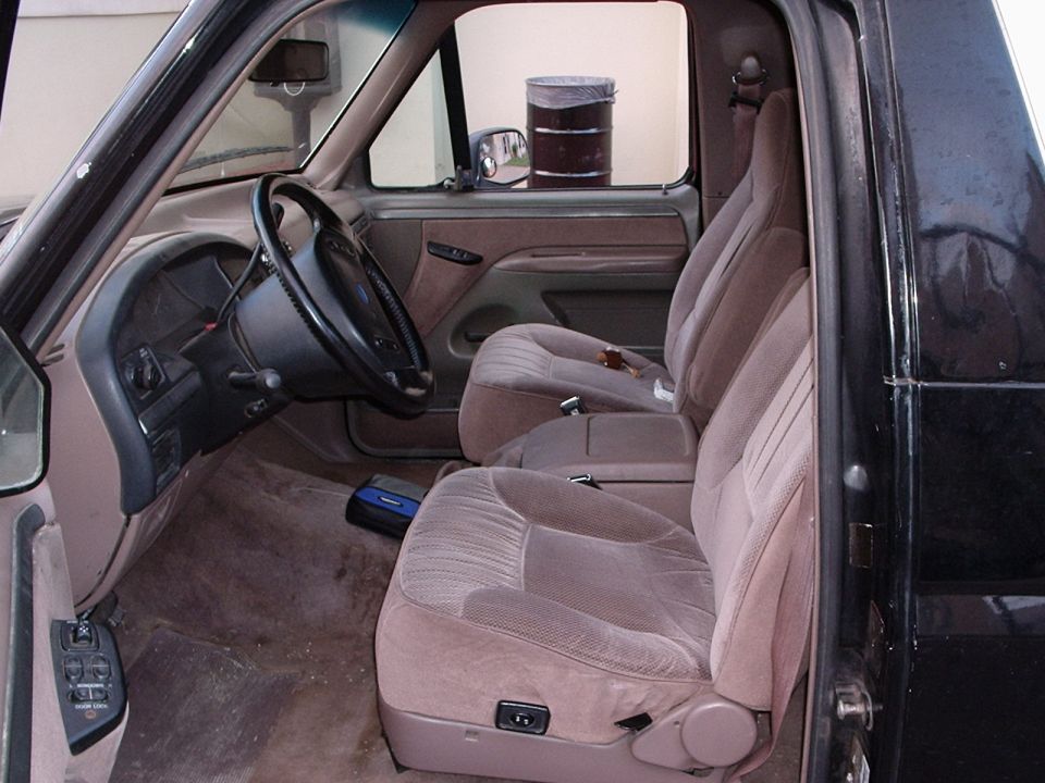 Interior of a 1992 Ford Bronco, showing tan cloth seats, dashboard, and steering wheel