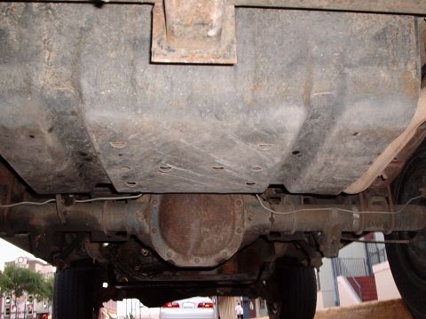 1993 Ford Bronco - Underside view of a vehicle's fuel tank and rear axle assembly.