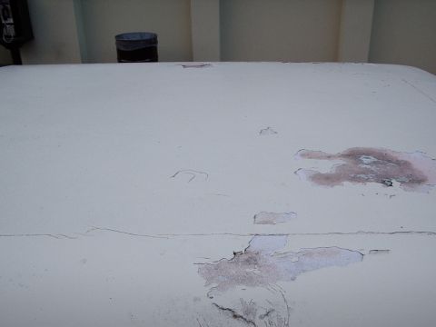 1993 Ford Bronco - The paint on this vehicle's roof is showing significant wear and tear, with rust appearing through the damaged areas.