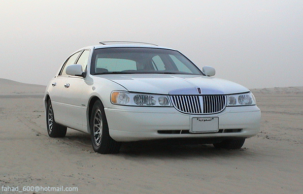 White sedan with chrome grille parked in desert