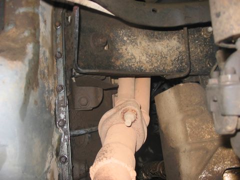 1988 Ford Bronco - Close-up view of the underside of a vehicle, focusing on exhaust components and frame.