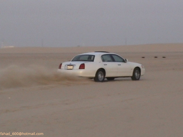 White 1999 Mercury Grand Marquis drifting in desert