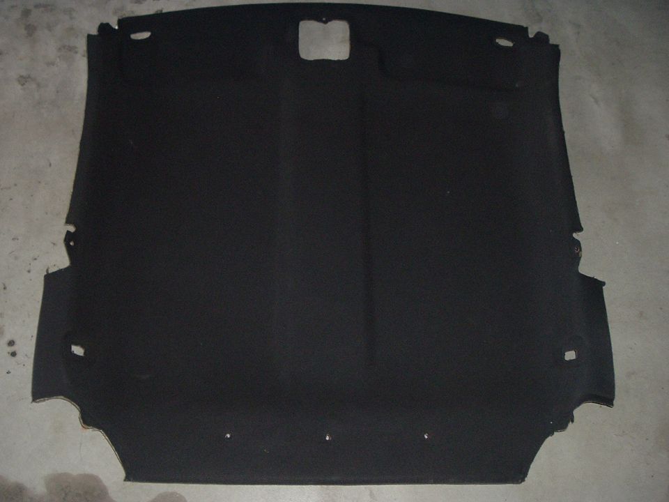 Black car headliner with cutouts for lights and sunroof