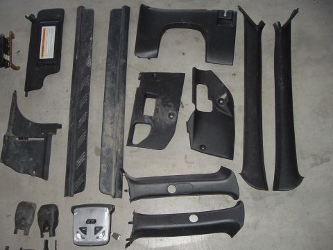 1994 Ford Probe - A collection of disassembled interior car parts are laid out on a gray surface.