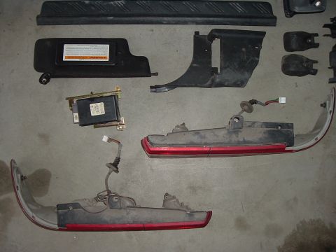1994 Ford Probe - Various disassembled car components are arranged on a flat surface, suggesting repair or replacement.