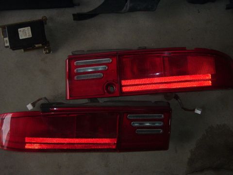 1994 Ford Probe - Pair of car taillights and an electronic control module, likely for replacement or repair.
