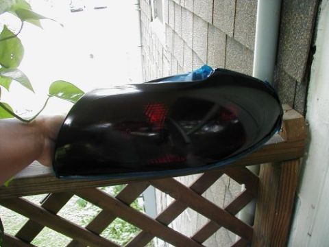 1997 Ford Taurus - A person holds a tinted tail light, likely a modification, with the Supermotors.net logo in the corner.