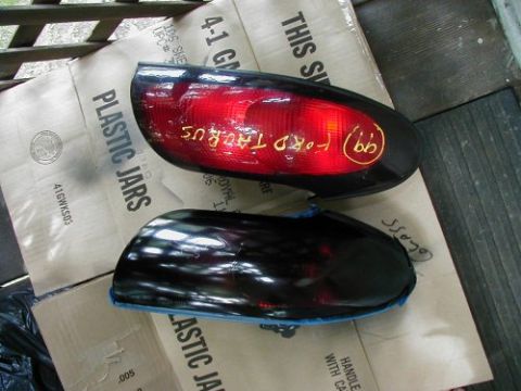 1997 Ford Taurus - Two Ford Taurus tail lights are shown, with handwritten markings on the red lens of one lens.