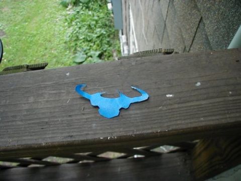1997 Ford Taurus - A blue bull emblem is placed on a wooden railing outdoors.