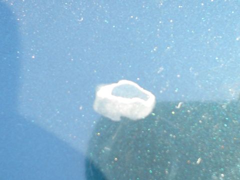 1993 Ford Taurus - Close-up of a paint chip on the blue metallic body of a car.