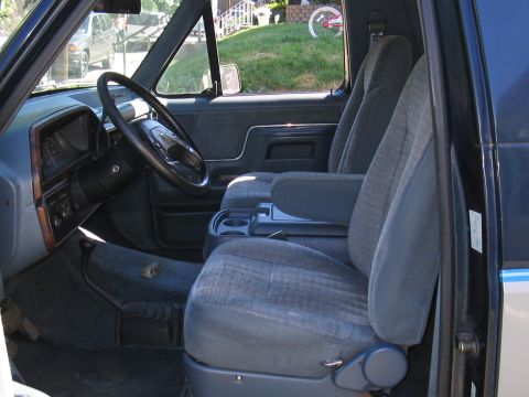 1979 Ford Bronco - The interior of the vehicle features cloth seats and a wood-grain trim on the dashboard.