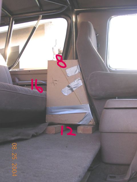 1994 Ford Bronco - A cardboard box is placed inside a vehicle's interior, supported by wooden blocks and marked with red numbers.