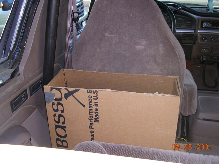 Cardboard Bassani exhaust box in the passenger footwell of a Ford truck interior