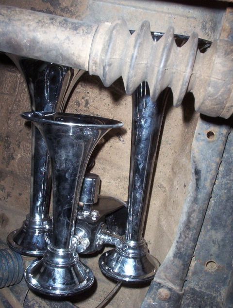 1989 Ford Bronco - Close-up of chrome air horns, a vehicle part, mounted beneath the chassis.