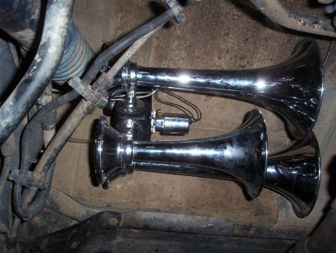 1989 Ford Bronco - Aftermarket dual chrome air horns are visible, mounted in the engine bay of a vehicle.