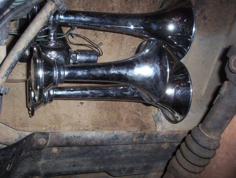 1989 Ford Bronco - Close-up of chrome air horns, likely an aftermarket addition to a vehicle.
