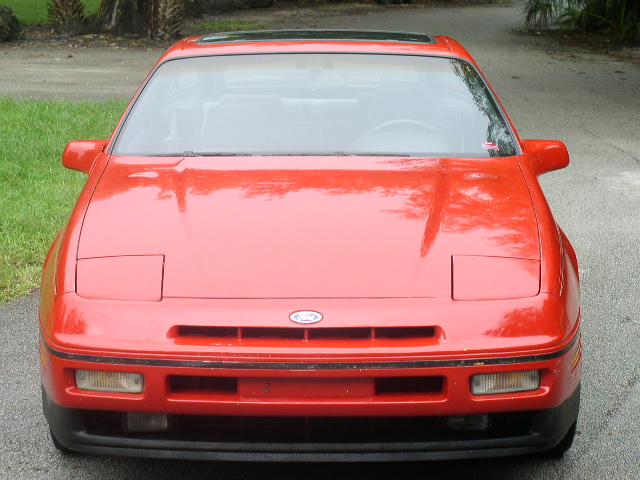 Front view of red Ford Probe with pop-up headlights down and Ford grille badge