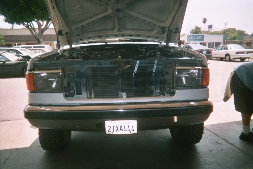Front of a Ford truck with hood up and grille removed showing the radiator