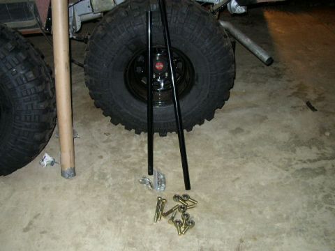 1995 Ford Bronco - Off-road tires and hardware are laid out on a garage floor.