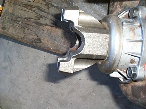 1994 Ford Bronco - Close-up view of a driveshaft yoke attached to a differential housing, with visible bolts and metal components.