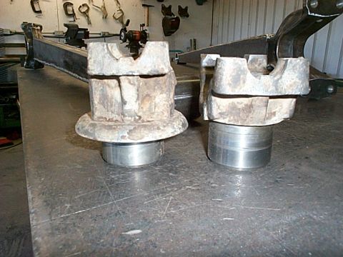 1994 Ford Bronco - Two differential housing components are shown side-by-side on a metal surface in a workshop setting.