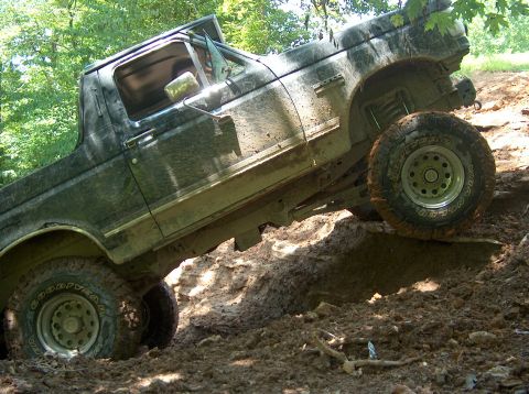 1989 Ford Bronco - This Ford Bronco is navigating a challenging muddy terrain, its off-road capabilities.