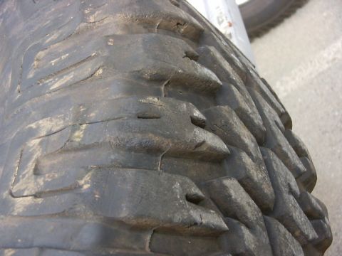 1990 Ford Bronco - A detailed view of a tire's tread pattern, showing significant wear and deep channels.