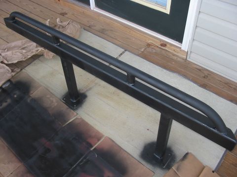 1988 Ford Bronco - Black metal sliders with two horizontal bars and vertical supports are shown on a wooden deck.
