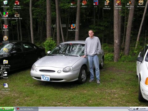 1998 Ford Taurus - A man poses with his silver 1998 Ford Taurus parked in a grassy, wooded area.