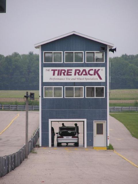 1998 Ford Taurus - A car is parked in the garage of The Tire Rack building at a race track.