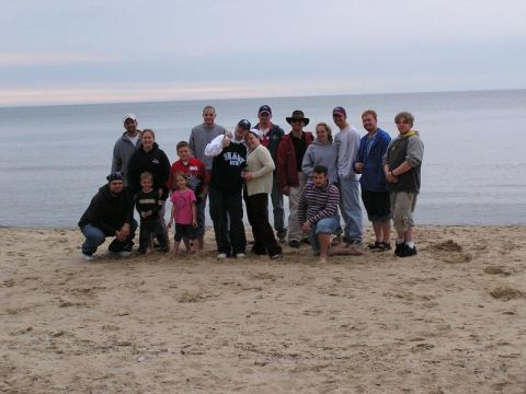 1998 Ford Taurus - A group of people gathered on a beach, posing for a photo with the ocean behind them.