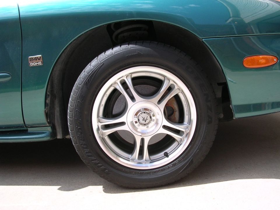 Green car fender and alloy wheel with a '24V DOHC' badge