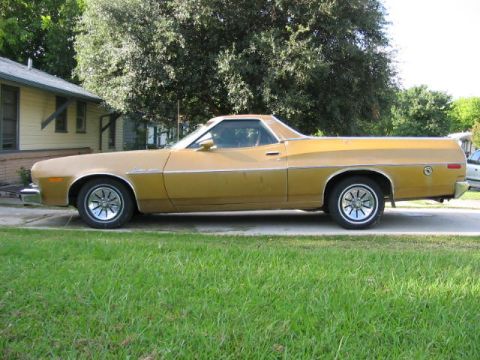 1974 Ford Ranchero - Side view of a gold 1974 Ford Ranchero pickup truck parked in front of a house.