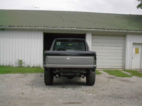 1989 Ford Bronco - This pickup truck, likely a Ford Bronco from the 1980s, is shown from the rear parked in front of a garage.