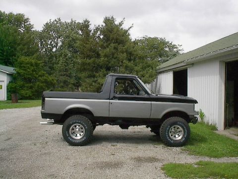 1989 Ford Bronco - Side view of a two-tone 1989 Ford Bronco with aftermarket wheels and tires.