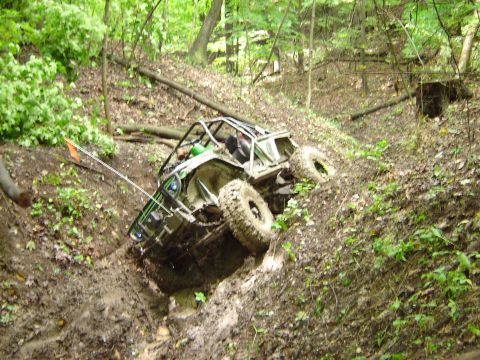 1992 Ford Bronco - Off-road buggy stuck in a steep, muddy incline surrounded by trees.