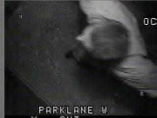 1985 Ford Bronco - Grainy black-and-white surveillance-style video still with 'PARKLANE W' overlaid at the bottom and a partial timestamp at upper right, show…