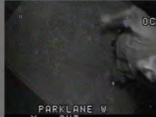 1985 Ford Bronco - Grainy black-and-white surveillance-style video still with a timestamp overlay and the caption text 'PARKLANE W' burned into the bottom of…