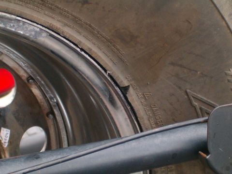 1996 Ford Bronco - A close-up view of a tire and rim shows damage to the tire's sidewall and rim edge.