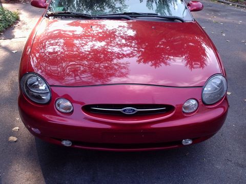 1998 Ford Taurus - The front grille and headlights of a red 1998 Ford Taurus are visible in this photo.