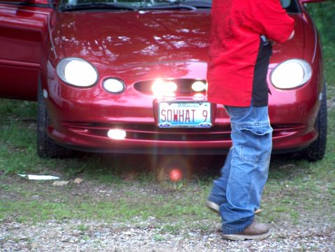 1998 Ford Taurus - The front of a red 1998 Ford Taurus is visible, its distinctive oval headlights and grille.