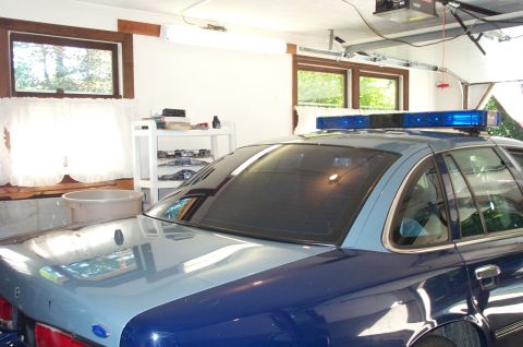 1991 Ford LTD Crown Victoria - This police car, identified as a 1991 Ford Crown Victoria LTD, is seen from the rear in a garage setting.