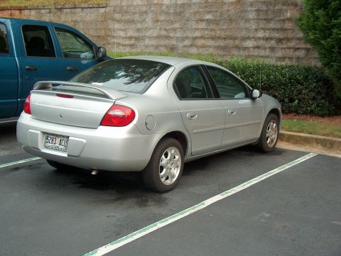 1998 Ford Taurus - A silver sedan is parked in a parking lot next to a blue truck.