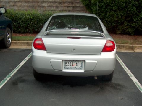 1998 Ford Taurus - Silver sedan with a spoiler parked next to a dark-colored truck.