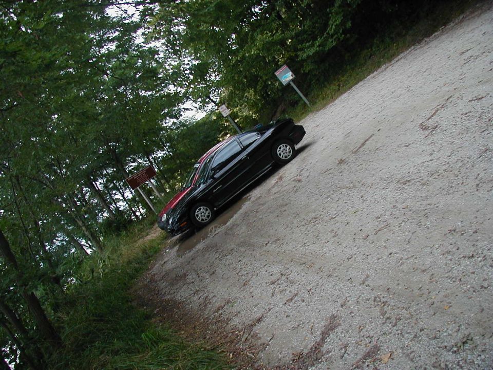 Black 1997 Ford Taurus sedan parked on a gravel road