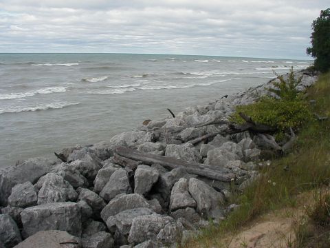 1997 Ford Taurus - A cloudy day at the beach with waves crashing against a rocky shore.